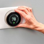 A person adjusting a sleek thermostat display showing 78°F, promoting energy management for Chad's AC Direct HVAC services.