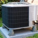 Modern air conditioning unit on concrete pad, surrounded by grass, from Chad's AC Direct HVAC services in Montgomery, AL.