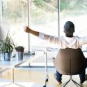Individual relaxing in an ergonomic chair in a modern office, highlighting Chad's AC Direct HVAC comfort and efficiency.