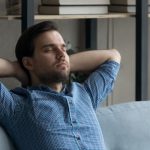 Man relaxing on a couch, demonstrating indoor comfort and tranquility, relevant to HVAC solutions and air quality improvement.